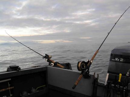 Photo of boat with two fishing poles set up one off of the back and the other off of the side of the boat