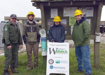 WDFW personnel and volunteers standing next to a monofilament recycling bin installed in Port Townsend, WA