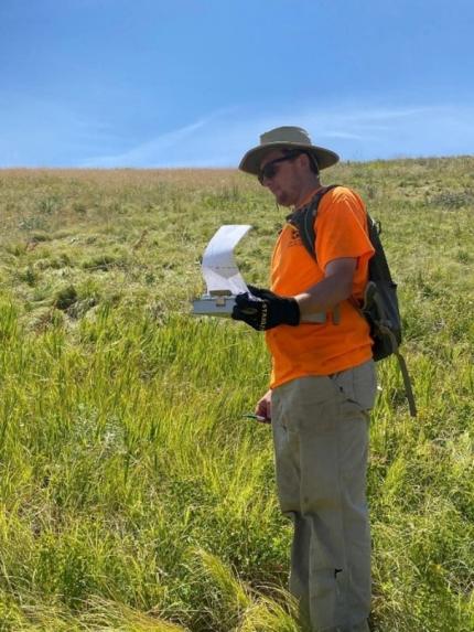 A person recording data in a field