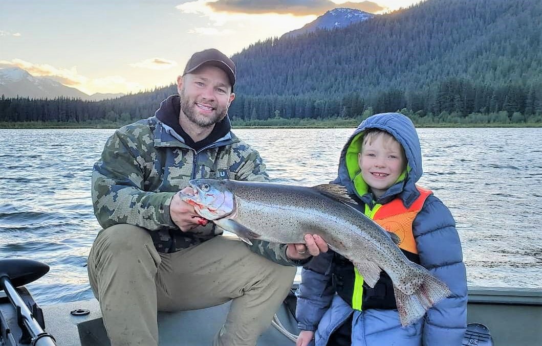 Father and son with a large rainbow trout caught on a Washington lake. Photo by Brian Dickison.