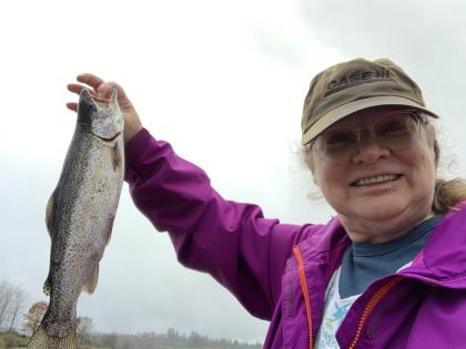 Woman holds up a 15" rainbow trout