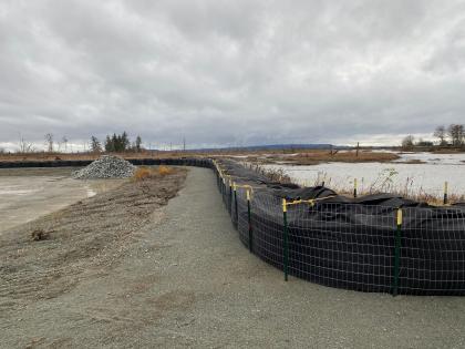 The temporary flood barrier, staged construction materials, and soft surfaces at Skagit Headquarters Unit in Dec. 2023