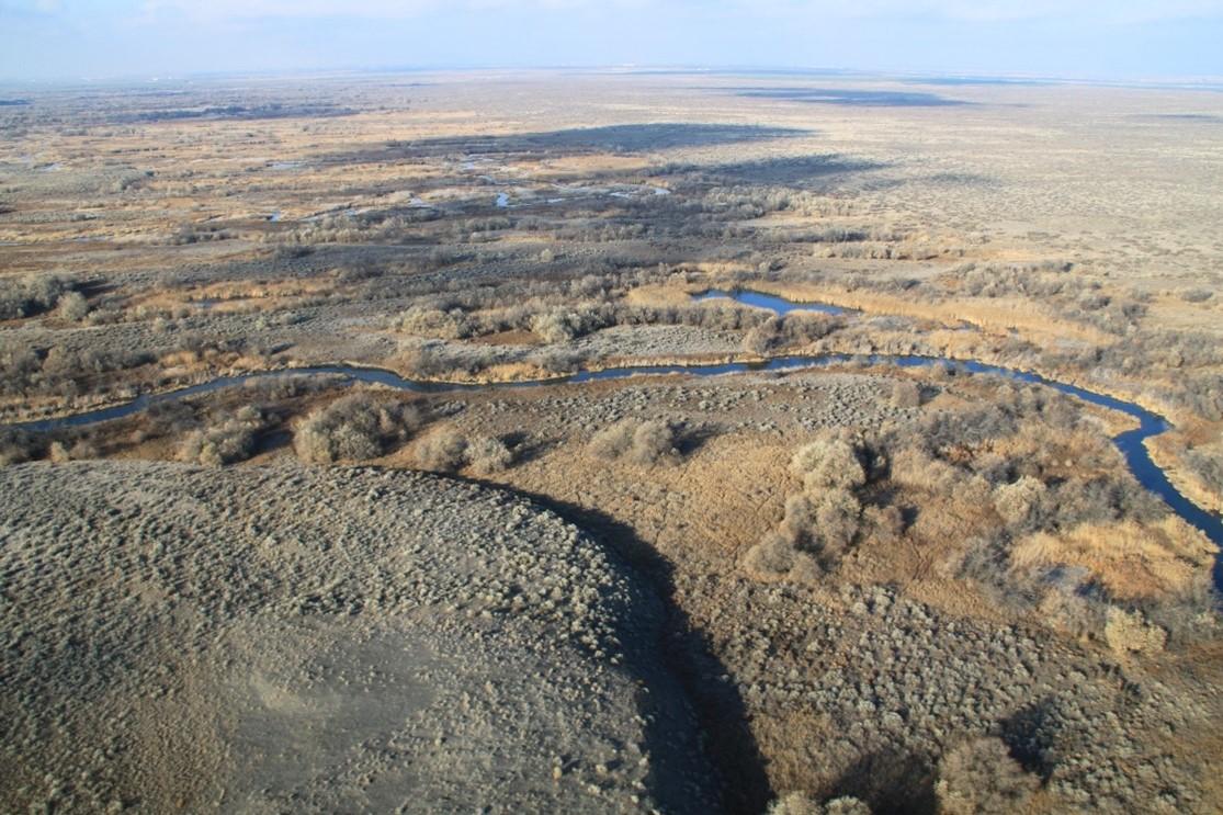 Aerial view of meandering waterway in arid landscape