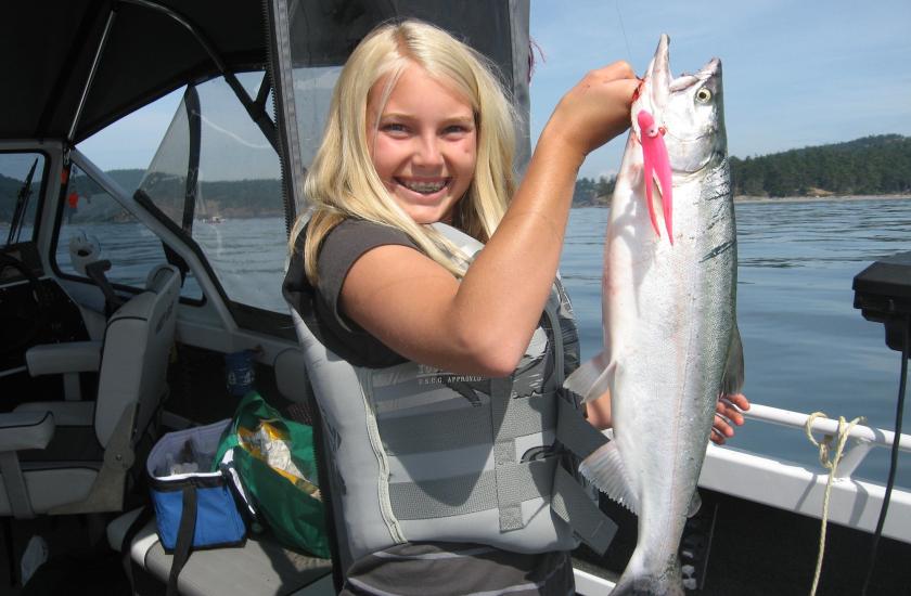 Young anglers holds up pink salmon catch.