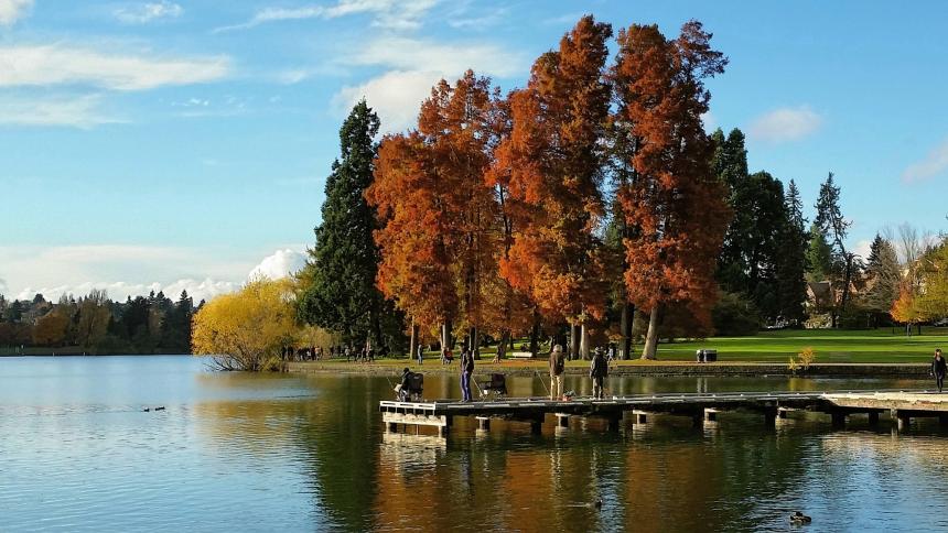 fishing dock at lake with fall colors on trees in the background