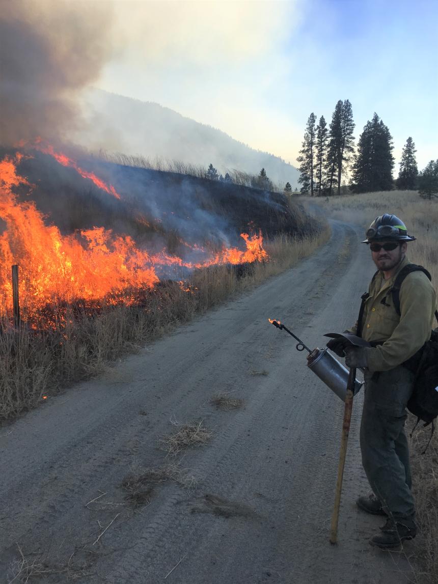 A firefighter watches a prescribed burn