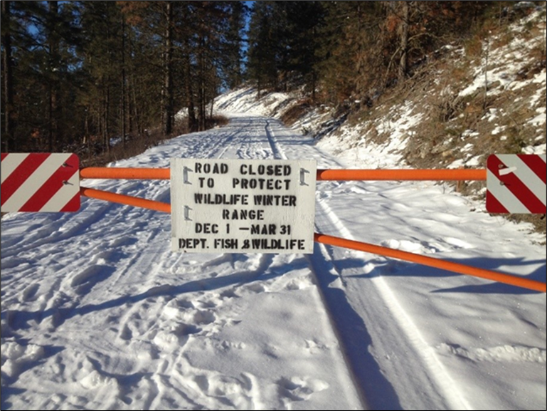 A road sign that reads "Road closed to protect wildlife winter range Dec 1 - March 31 Department of Fish and Wildlife."