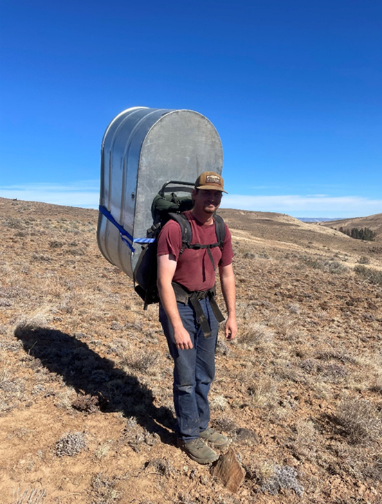 Habitat Specialist Miller getting ready to haul a trough into Little Pine Canyon.