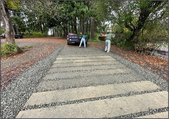 Two people spreading gravel at Island Lake. 