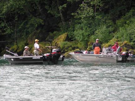 Two boats anchored next to one another with anglers plunking.