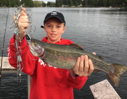 Young angler holds up a 17-inch rainbow trout