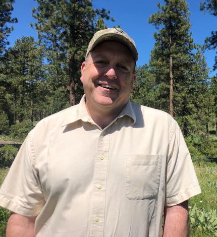 WDFW Director Kelly Susewind outside smiling in a baseball cap