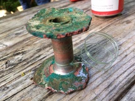 A rotted fishing reel that had been under water for years but with intact fishing line still attached