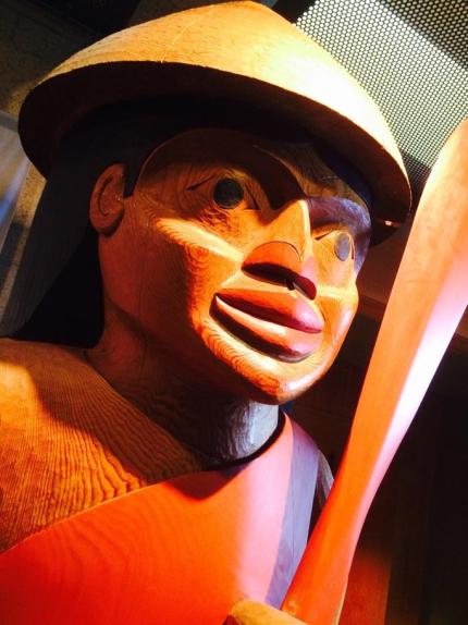 Salish cedar carved welcome figure holding a canoe paddle