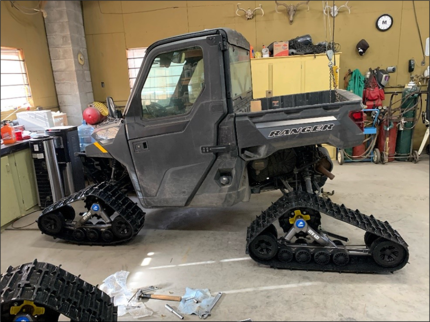 A utility terrain vehicle with wheels swapped to treads