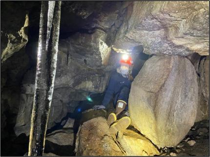 Technician Motiff crawling into a small cave tunnel