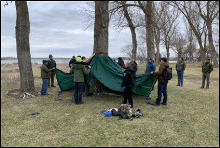 A handful of people conducting training near trees.