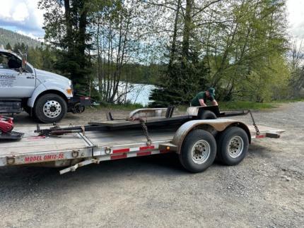 An abandoned trailer loaded onto another trailer.