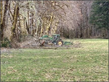 Assistant Manager Gallegos pushing broken alder branches off the Pinkney field