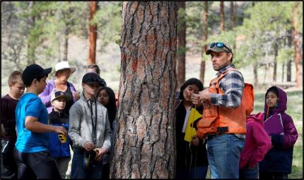 DNR District Manager Townsend teaching how to measure tree DBH. 