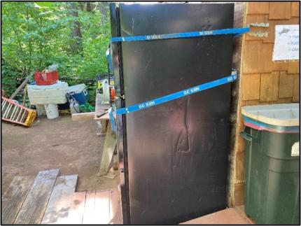 An outdoor refrigerator damaged by a bear.