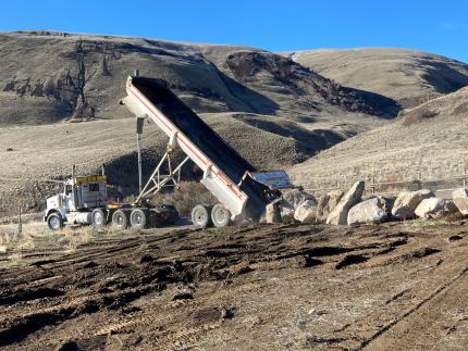 A truck laying out a line of rocks