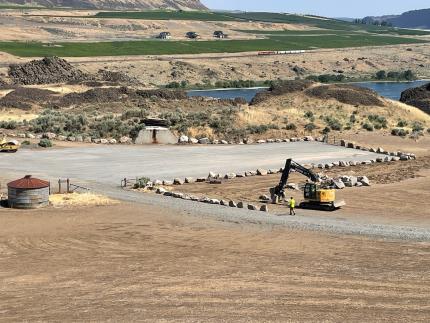 A tractor adjusting rock at a parking lot