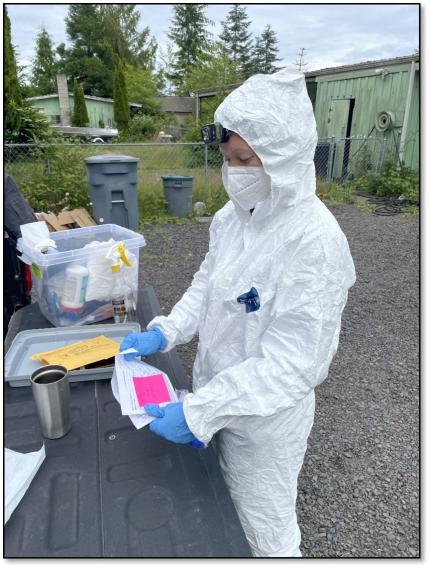 Biologist Stephens wearing PPE in preparation for entering an attic space to collect bat guano 