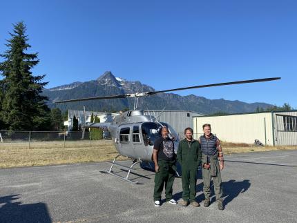 Price, Licence, and Collins standing next to a helicopter.