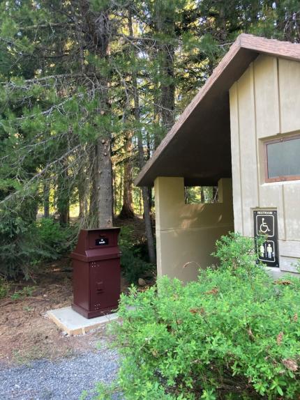 A bear proof trashcan next to a building