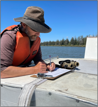 Biologist Novack recording data at the Chehalis Estuary site. 