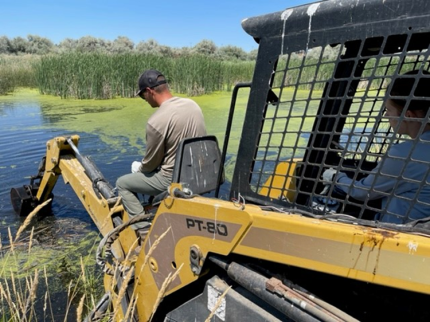 Assistant Manager Jahns and Natural Resource Technician Manderbach clearing debris from 7-acre outflow.