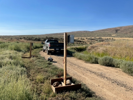 A truck on a road just past a sign