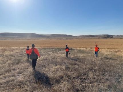 Several youth hunters in a field