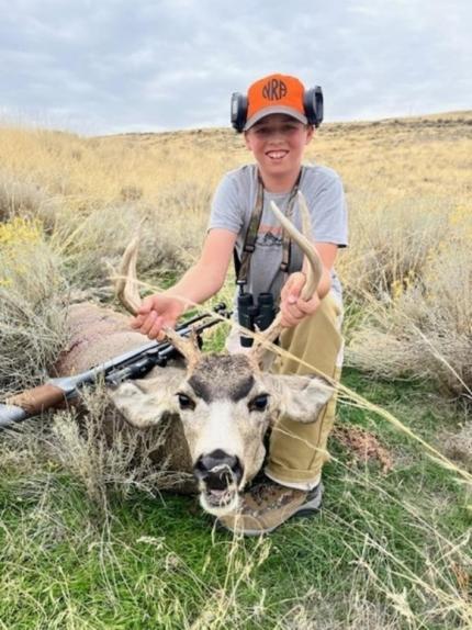 Youth hunter with recently harvested mule deer. 