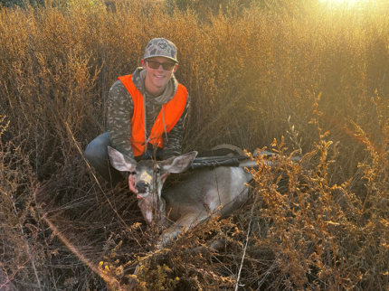 A young hunter with a recently harvested deer.  