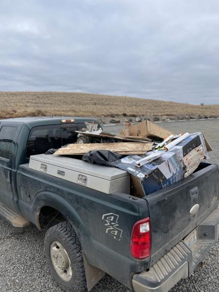 A pickup with trash collected in the bed.