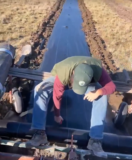 Staff member laying fabric out on a field