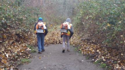 Two staff members using lead blowers clearing a path