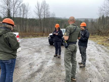 Four people participating in a discussion at the North Fork Toutle River access location.