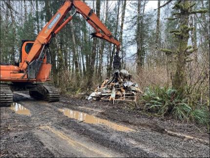 The remains of an RV being lifted by a tractor