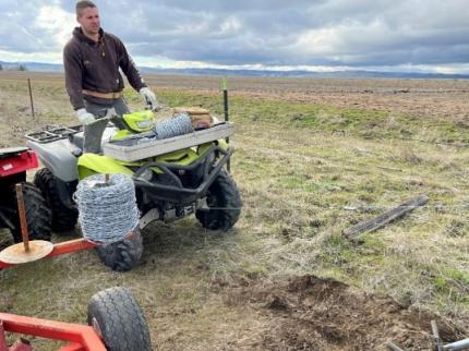 An ATV stretching wire for a fence