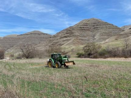 Dice driving the tractor and spraying fields at Joseph Creek.