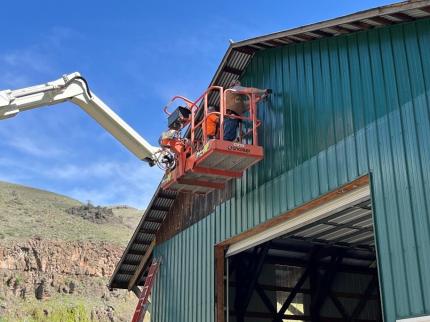 Installing metal siding on the gable end of the South Fork Hayshed 