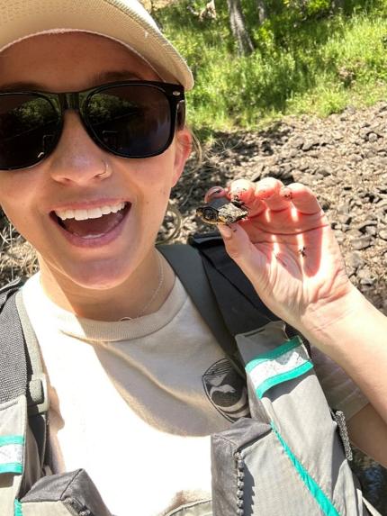 Staff member taking a selfie with a tiny turtle. 