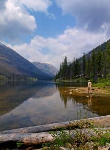 Angler fishes at alpine lake.