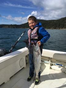 Young angler holds up chinook salmon caught off the San Juan Islands