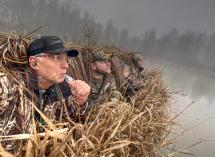 Four waterfowl hunters sitting outdoors