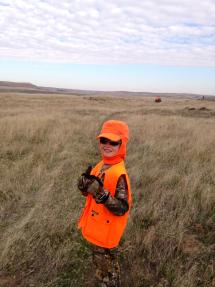A young boy in hunter orange