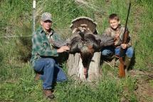 A child and grandpa with a harvested turkey